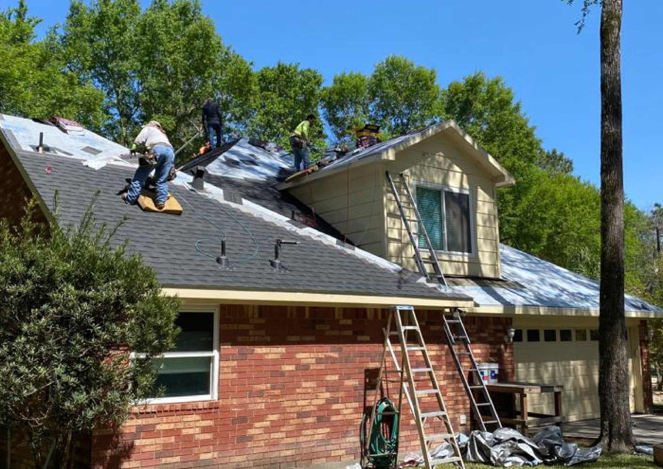 A professional team installing a new roof on a residential home in Houston, Texas with RM Roofing.