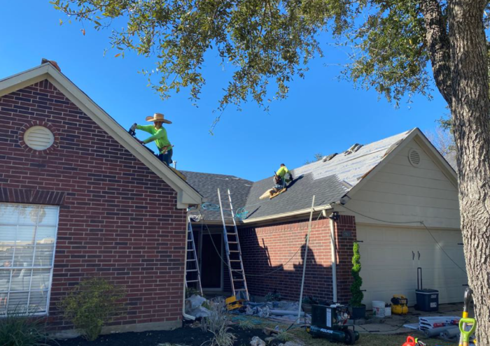 A professional team installing a new roof on a residential home in Houston, Texas with RM Roofing.